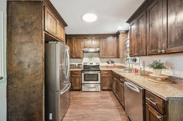 a kitchen with granite countertop stainless steel appliances and wooden cabinets