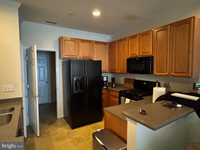 a kitchen with stainless steel appliances granite countertop a refrigerator stove top oven and sink