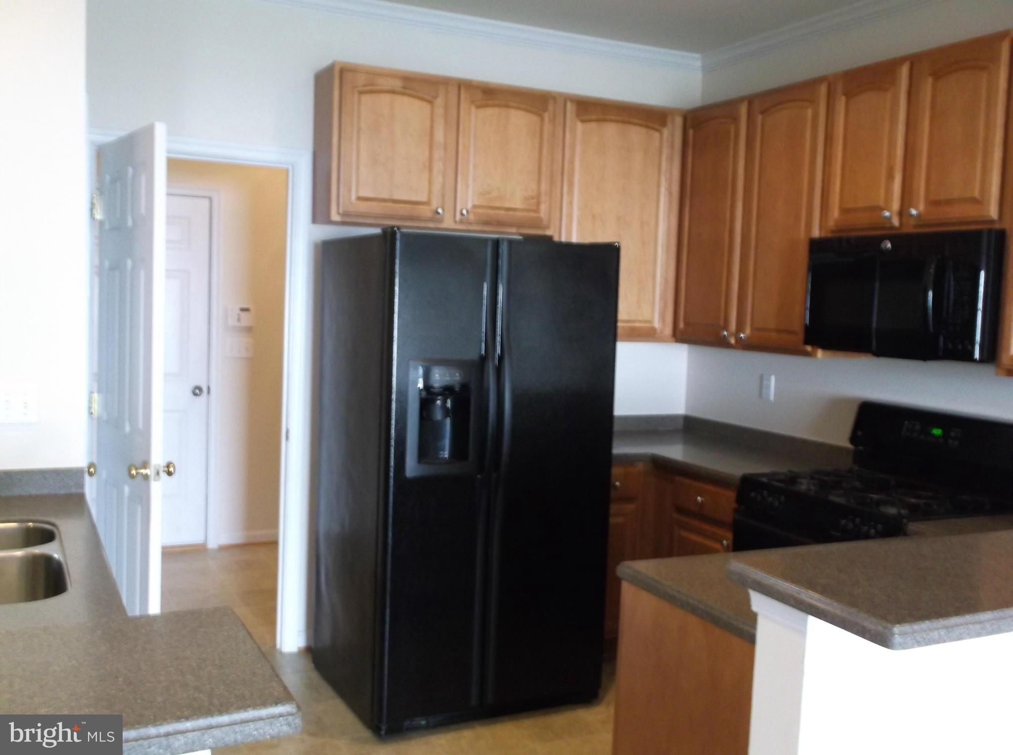 542 Summerset Court, Unit 39 Solomons, MD 20629 - Photo 7 of 39 a kitchen with granite countertop a refrigerator and a stove top oven
