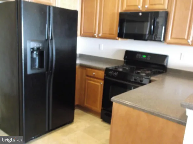 a kitchen with a refrigerator and a stove top oven