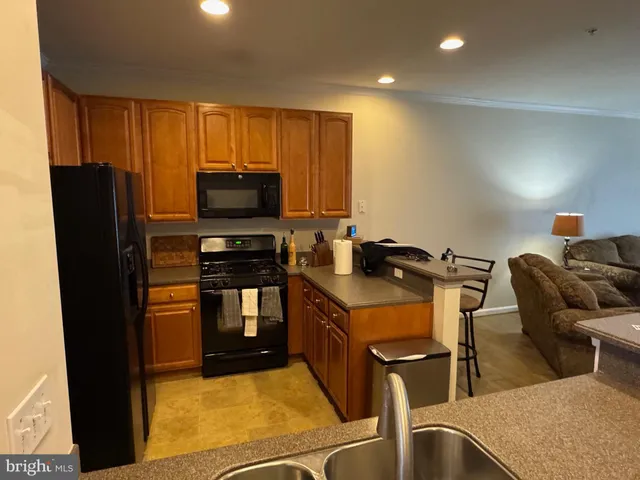 a kitchen with stainless steel appliances granite countertop a refrigerator a stove top oven a sink and dishwasher