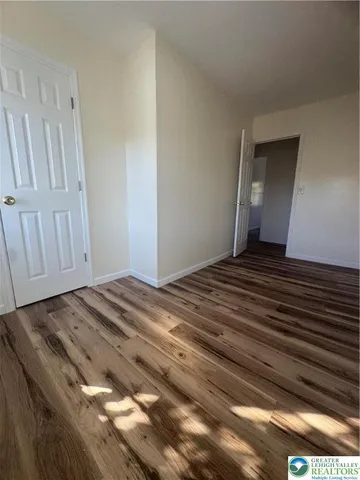 a view of a room with wooden floor
