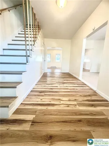 a view of entryway and hall with wooden floor