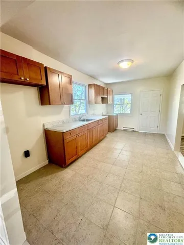a large white kitchen with a sink and cabinets