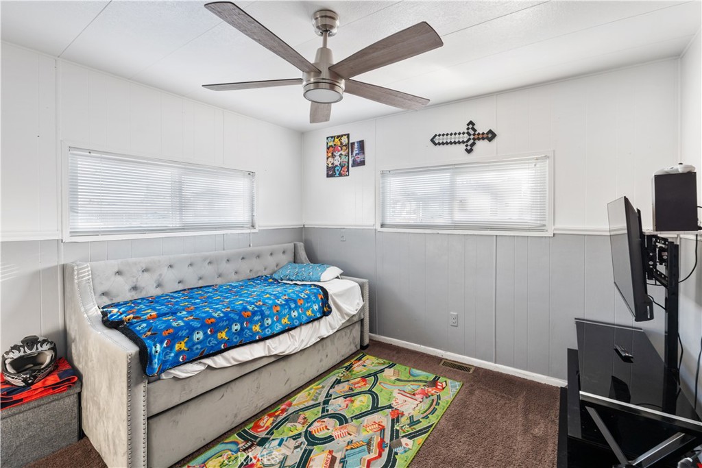 1000 Windy Pass, Unit 146 Barstow, CA 92311 - Photo 13 of 29 a bedroom with a bed and a flat tv screen on the dresser
