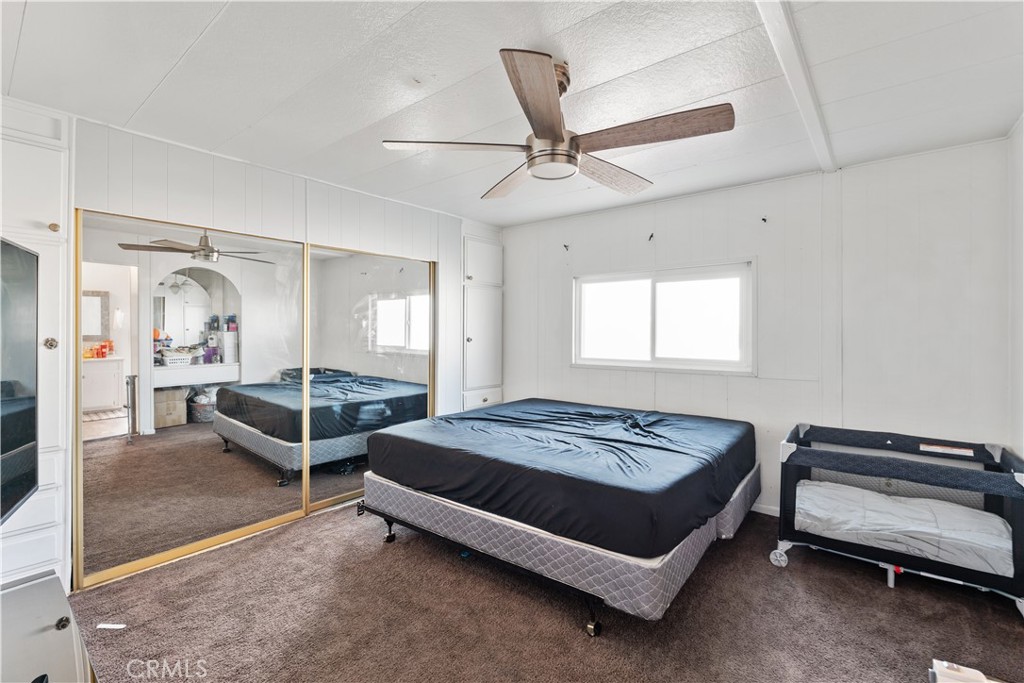 1000 Windy Pass, Unit 146 Barstow, CA 92311 - Photo 17 of 29 a bedroom with a bed and a chandelier