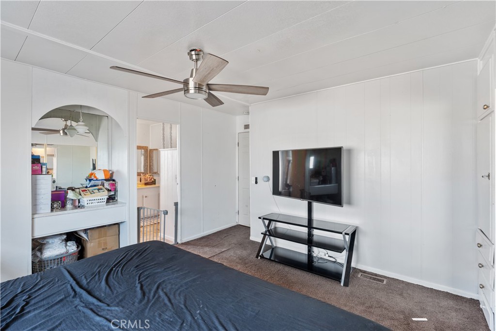 1000 Windy Pass, Unit 146 Barstow, CA 92311 - Photo 18 of 29 a bedroom with a bed and a flat screen tv