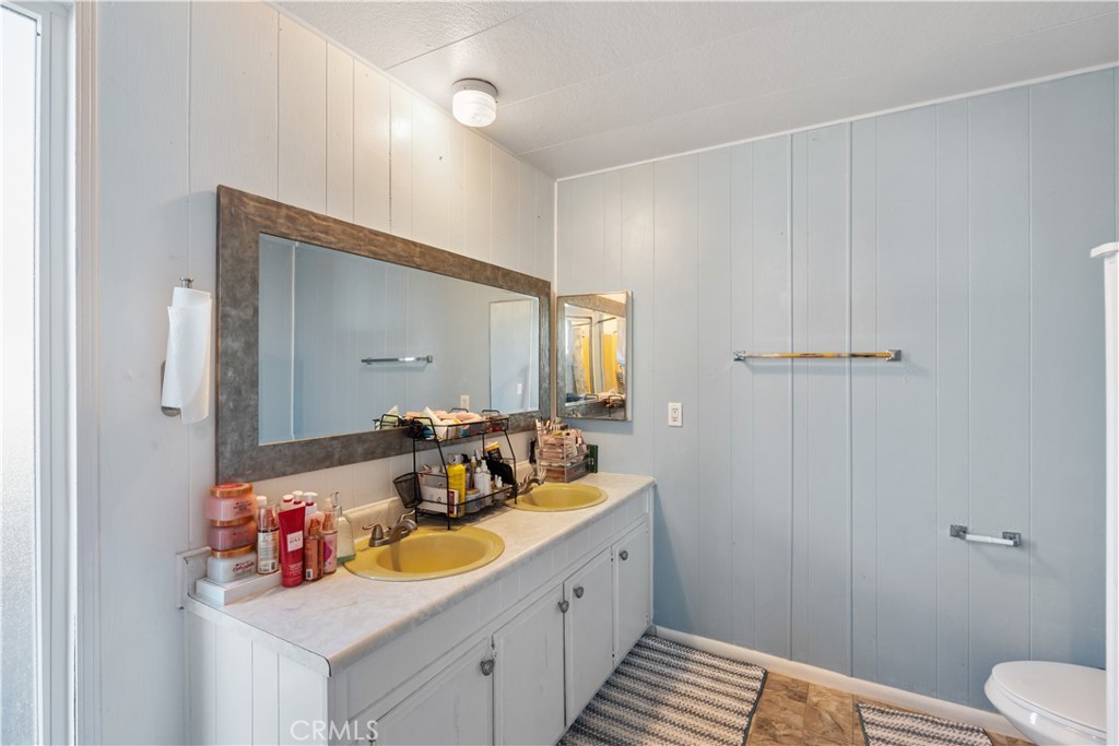 1000 Windy Pass, Unit 146 Barstow, CA 92311 - Photo 19 of 29 a bathroom with a sink mirror vanity and toilet