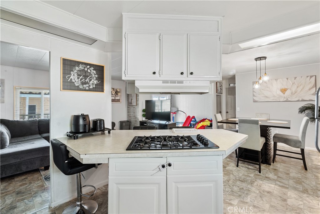 1000 Windy Pass, Unit 146 Barstow, CA 92311 - Photo 9 of 29 a kitchen with a stove and white cabinets