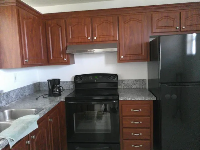 a kitchen with granite countertop stainless steel appliances and cabinets