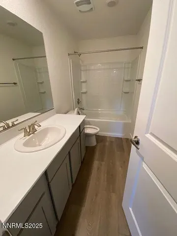a bathroom with a sink a toilet a mirror and shower