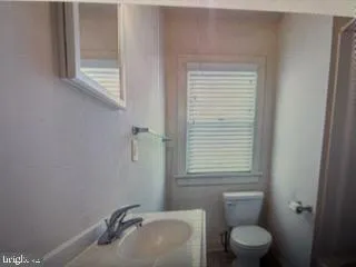 a bathroom with a sink a toilet and a mirror