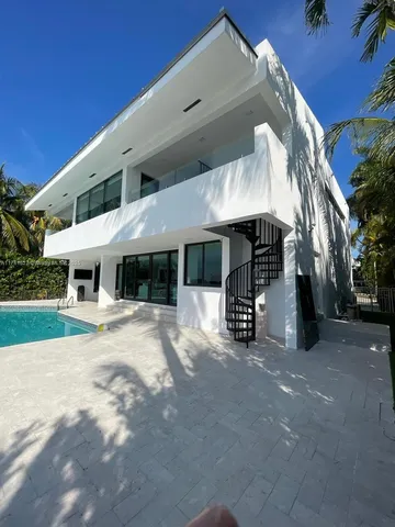 a swimming pool with outdoor seating and plants