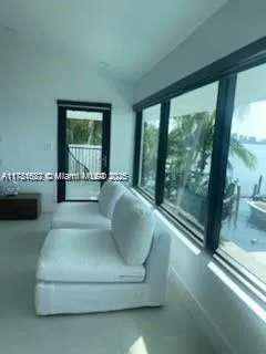 a living room with furniture and a floor to ceiling window