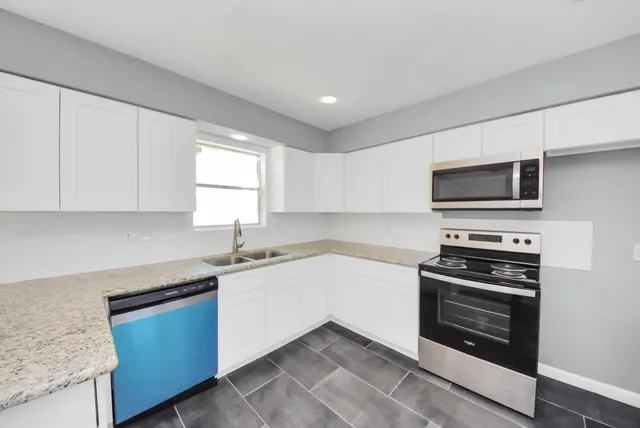 a kitchen with granite countertop a sink and steel appliances