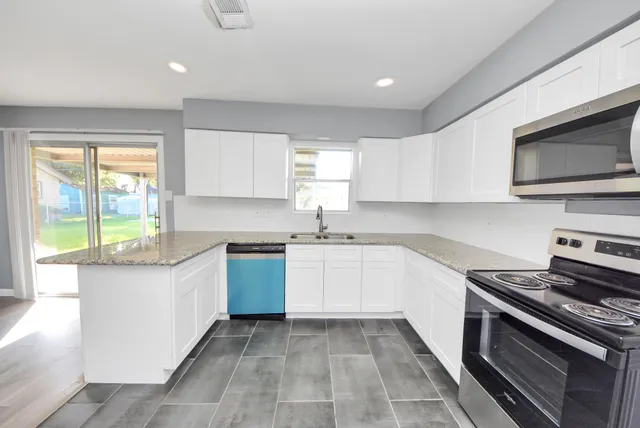 a kitchen with stainless steel appliances a stove sink microwave and cabinets