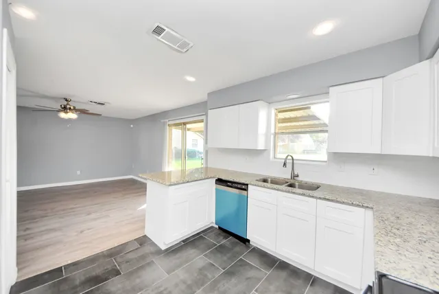 a kitchen with a sink cabinets stainless steel appliances and a window