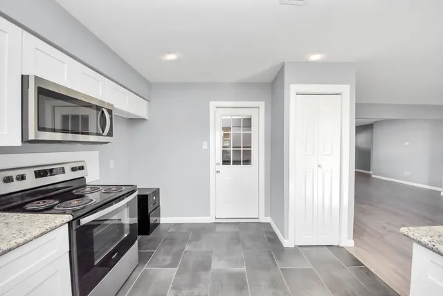 a kitchen with granite countertop a stove top oven and sink