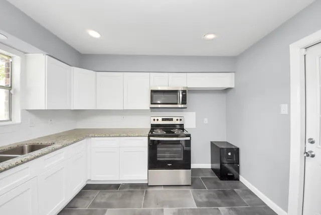 a kitchen with stainless steel appliances granite countertop a stove and a refrigerator