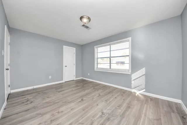 wooden floor in an empty room with a window