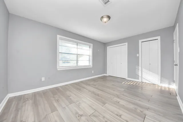 wooden floor in an empty room with a window