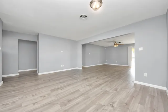 a view of an empty room with wooden floor