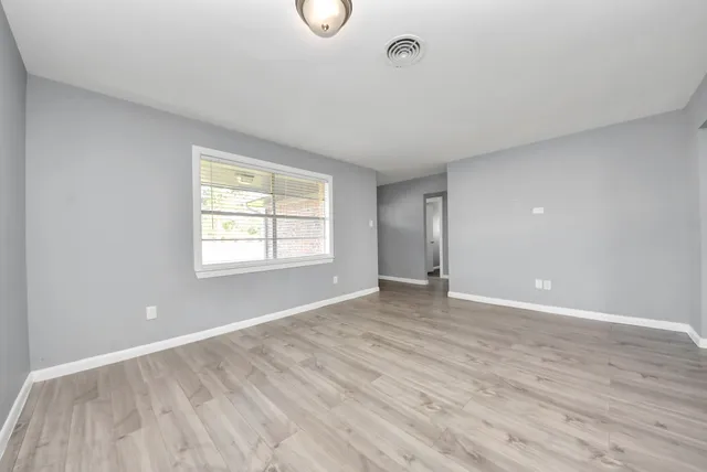 wooden floor in an empty room with a window