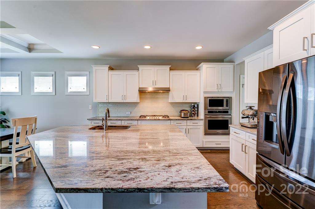 5409 Meadowcroft Way Fort Mill, SC 29708 - Photo 13 of 34 a kitchen with kitchen island granite countertop a table chairs microwave and refrigerator