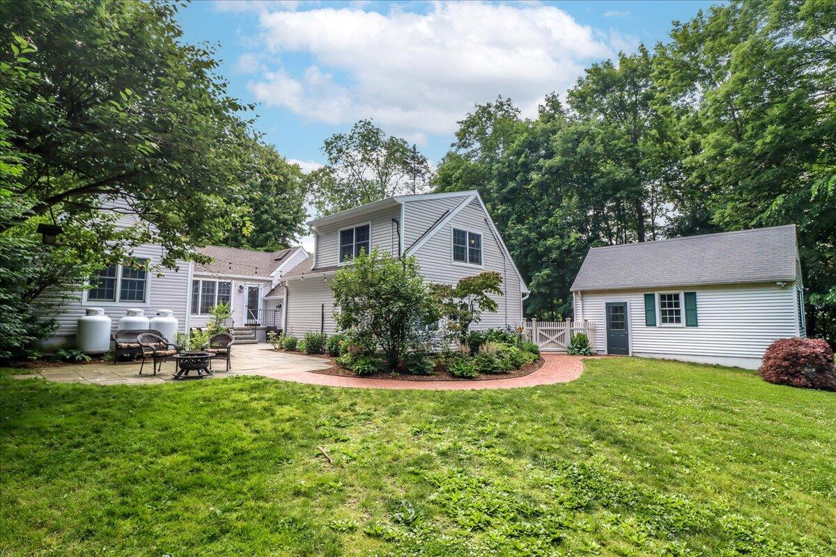 262 White Oak Shade Road New Canaan, CT 06840 - Photo 32 of 37 a front view of a house with a garden and trees