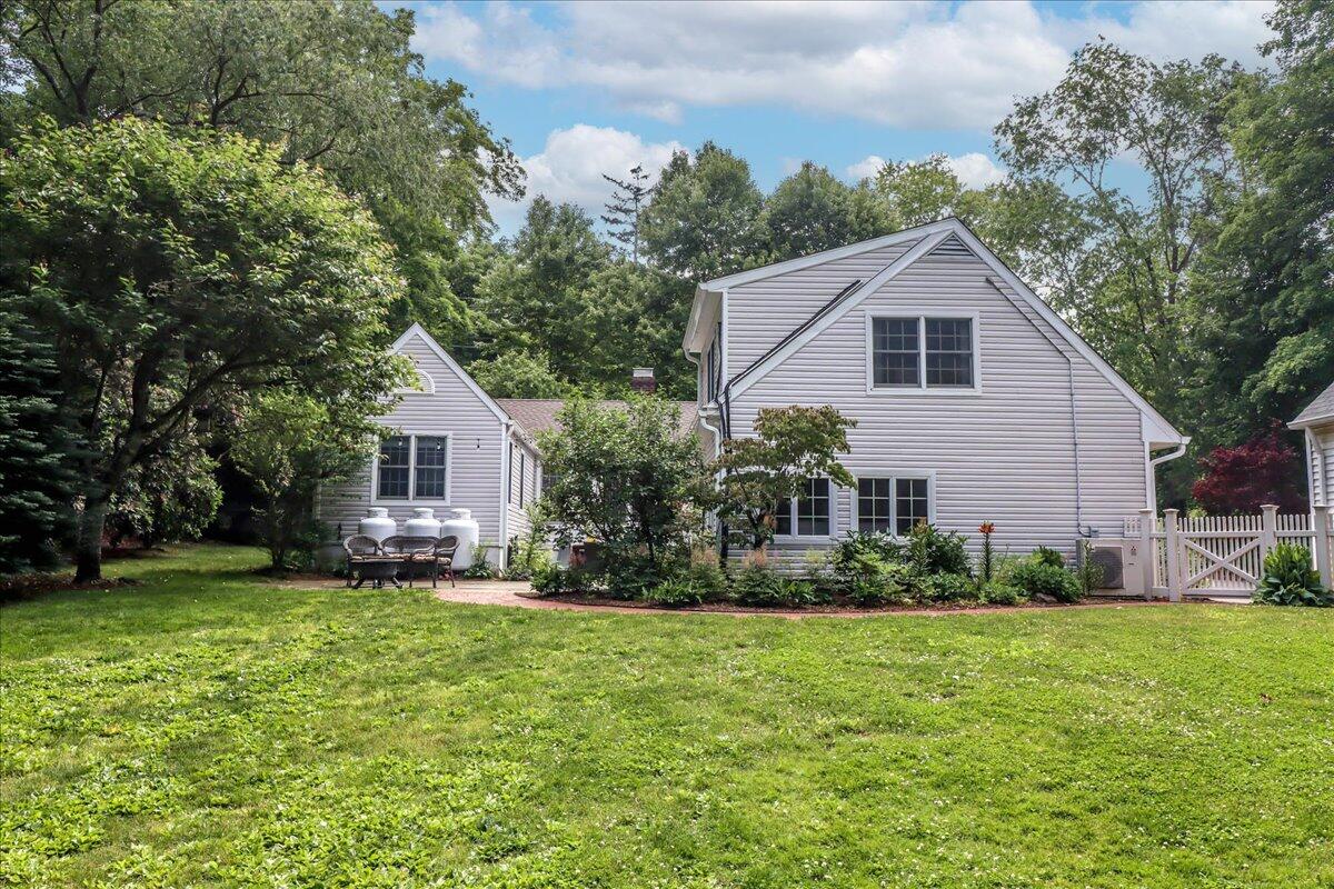 262 White Oak Shade Road New Canaan, CT 06840 - Photo 33 of 37 a front view of a house with a garden and yard