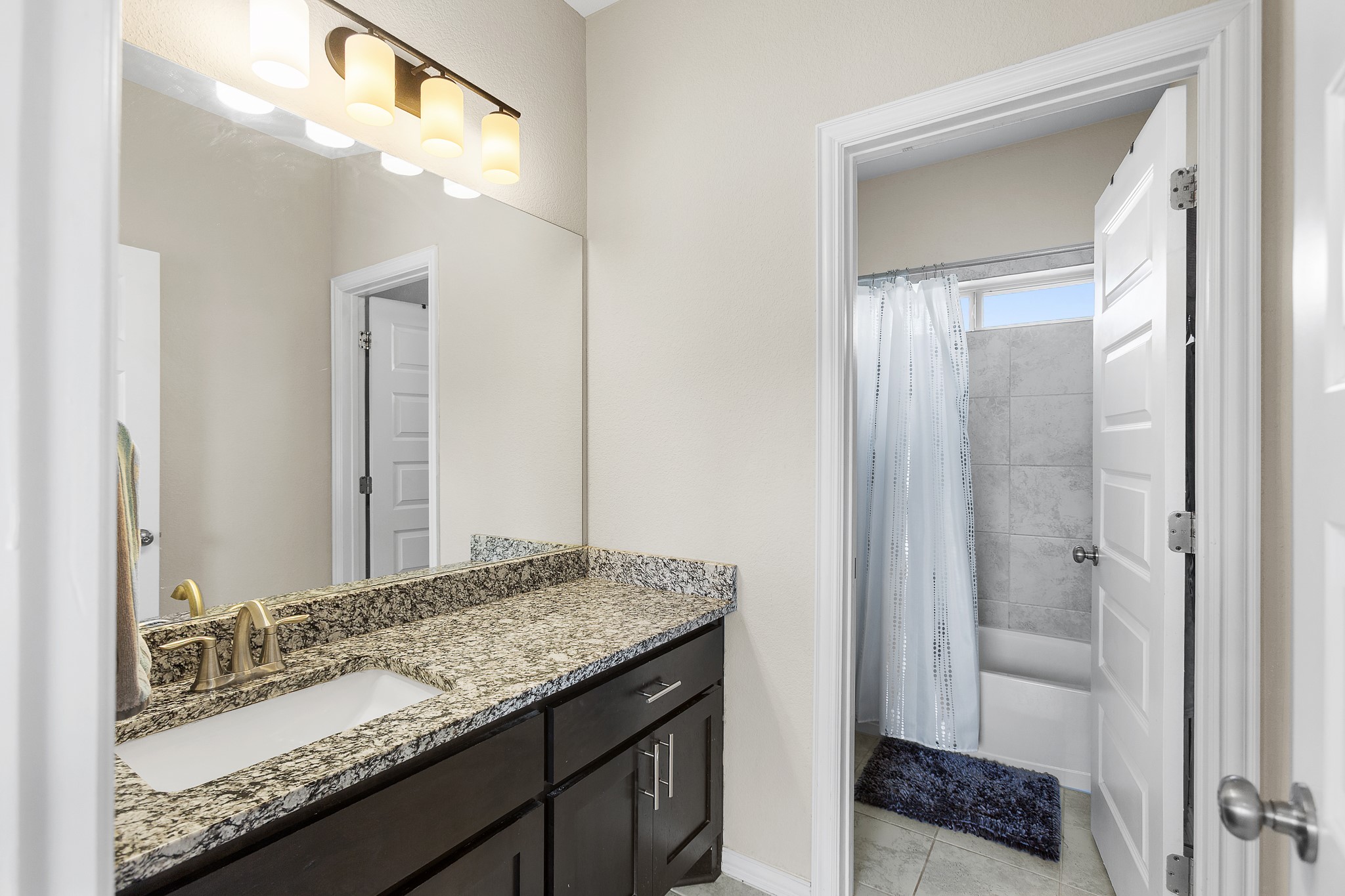8709 Slater Drive Austin, TX 78747 - Photo 30 of 36 a bathroom with a granite countertop sink and a mirror