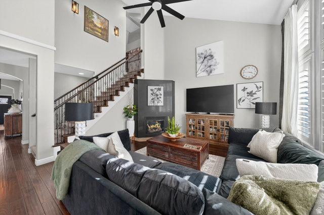 14738 Tangle Hill Road Herriman, UT 84096 - Photo 23 of 66 Spacious living area featuring high ceilings, wood-finish flooring, a contemporary fireplace, and a prominent staircase with wrought iron balusters