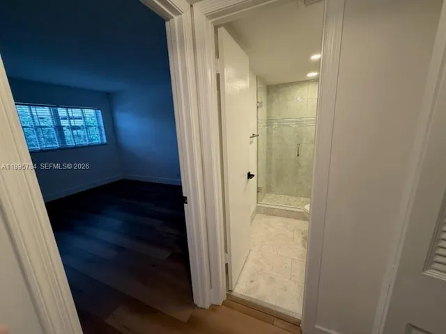 a view of a room with wooden floor and a window