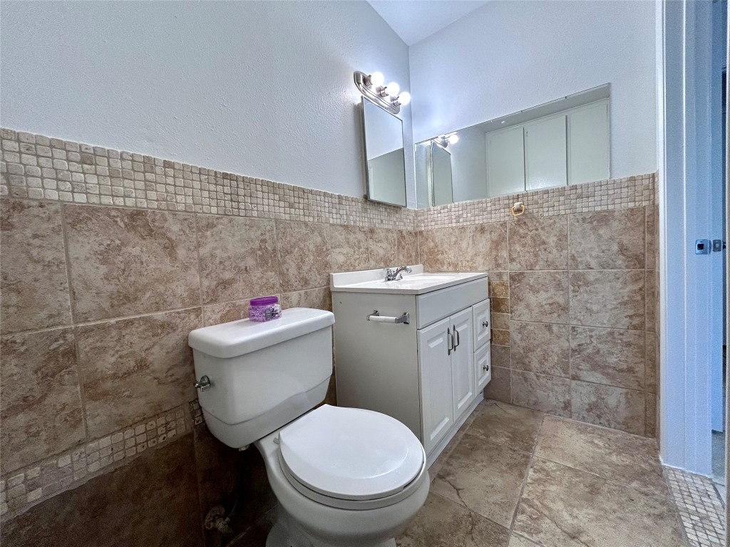 6200 Palm Circle Austin, TX 78741 - Photo 15 of 18 a bathroom with a toilet sink vanity and mirror