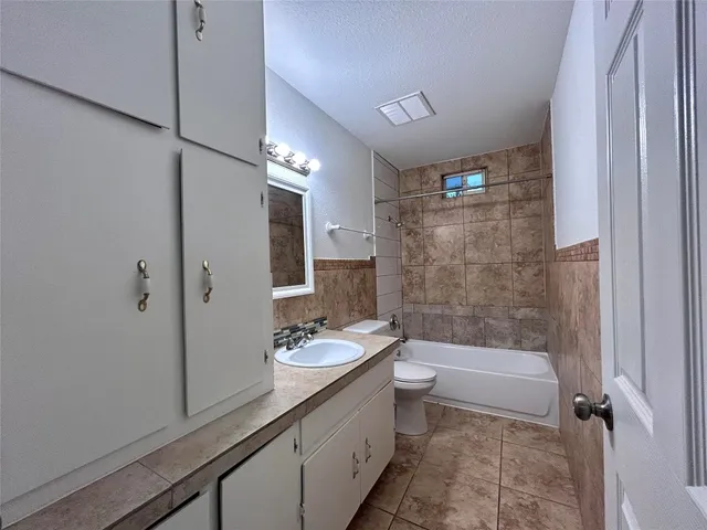 a bathroom with a granite countertop toilet a sink and a mirror
