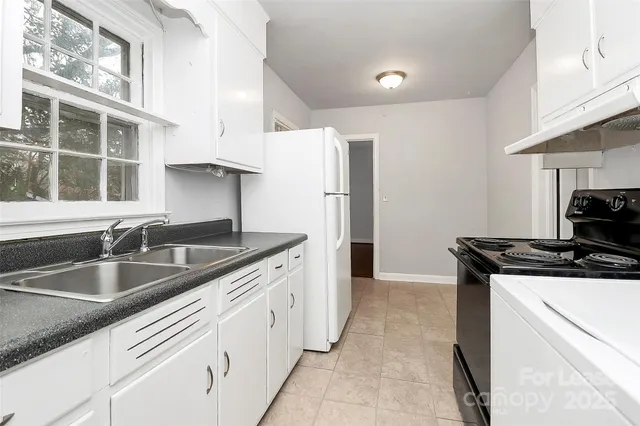 a kitchen with granite countertop a sink stove and refrigerator