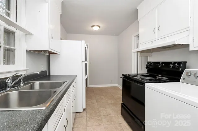 a kitchen with granite countertop a sink and a stove