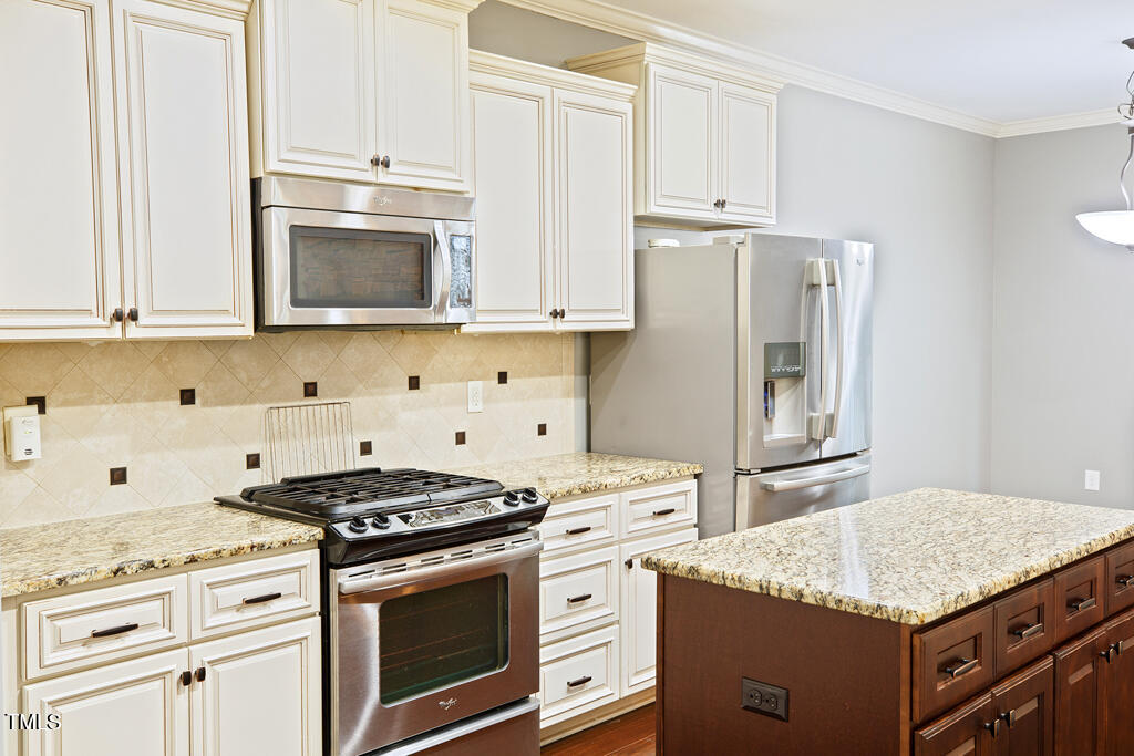 337 Shadowdale Lane Rolesville, NC 27571 - Photo 11 of 74 a kitchen with granite countertop cabinets stainless steel appliances and wooden cabinets