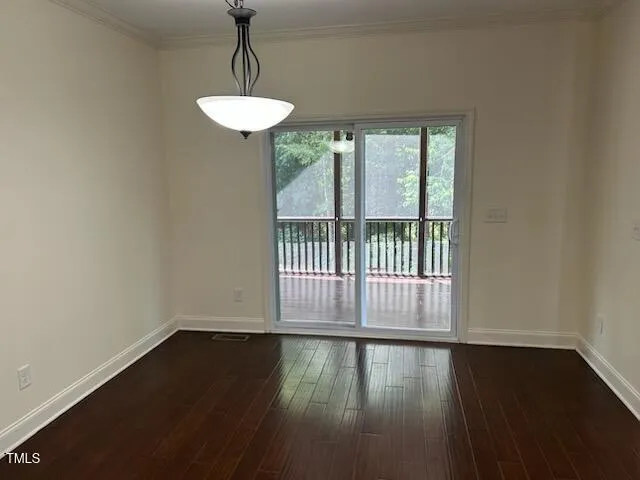 an empty room with wooden floor fireplace and windows