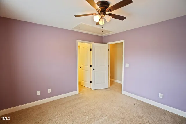 an empty room with closet and a chandelier fan