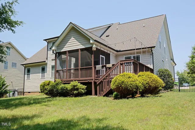 a view of a house with a big yard plants and large trees