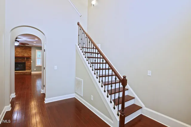 a view of a hallway with wooden floor and a chandelier
