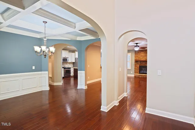 a kitchen with granite countertop a refrigerator stove and sink with wooden floor