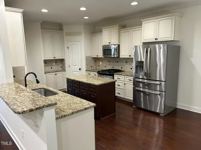 a kitchen with granite countertop cabinets stainless steel appliances and wooden cabinets