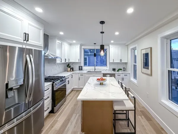 a kitchen with kitchen island a refrigerator stove microwave and cabinets