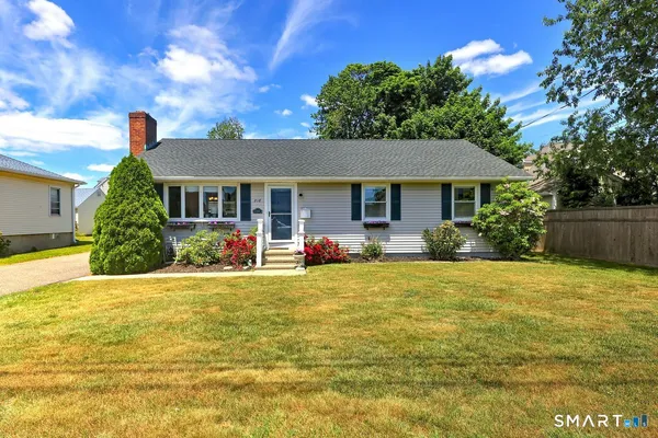 a front view of a house with yard and green space