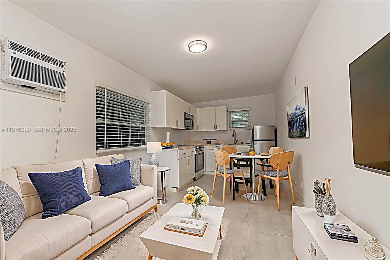 259 Northeast 56th Street, Unit 2 Miami, FL 33137 - Photo 6 of 23 a living room with furniture and a flat screen tv with wooden floor