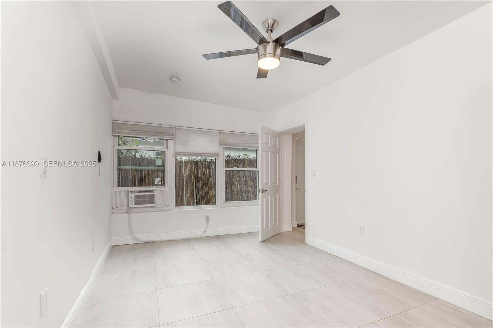 259 Northeast 56th Street, Unit 2 Miami, FL 33137 - Photo 10 of 23 an empty room with windows and fan