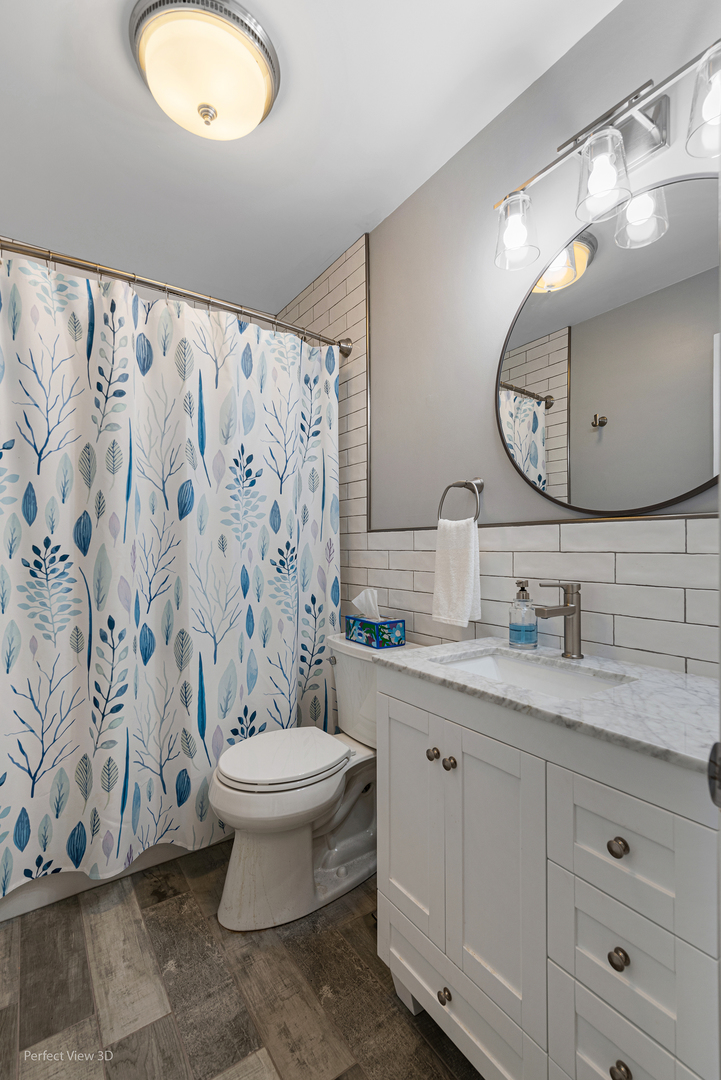 100 White Oak Drive Lindenhurst, IL 60046 - Photo 11 of 22 a bathroom with a granite countertop toilet sink and mirror