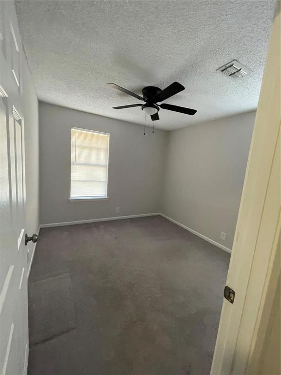 117 East Prospect Street Denison, TX 75021 - Photo 8 of 13 an empty room with windows and fan